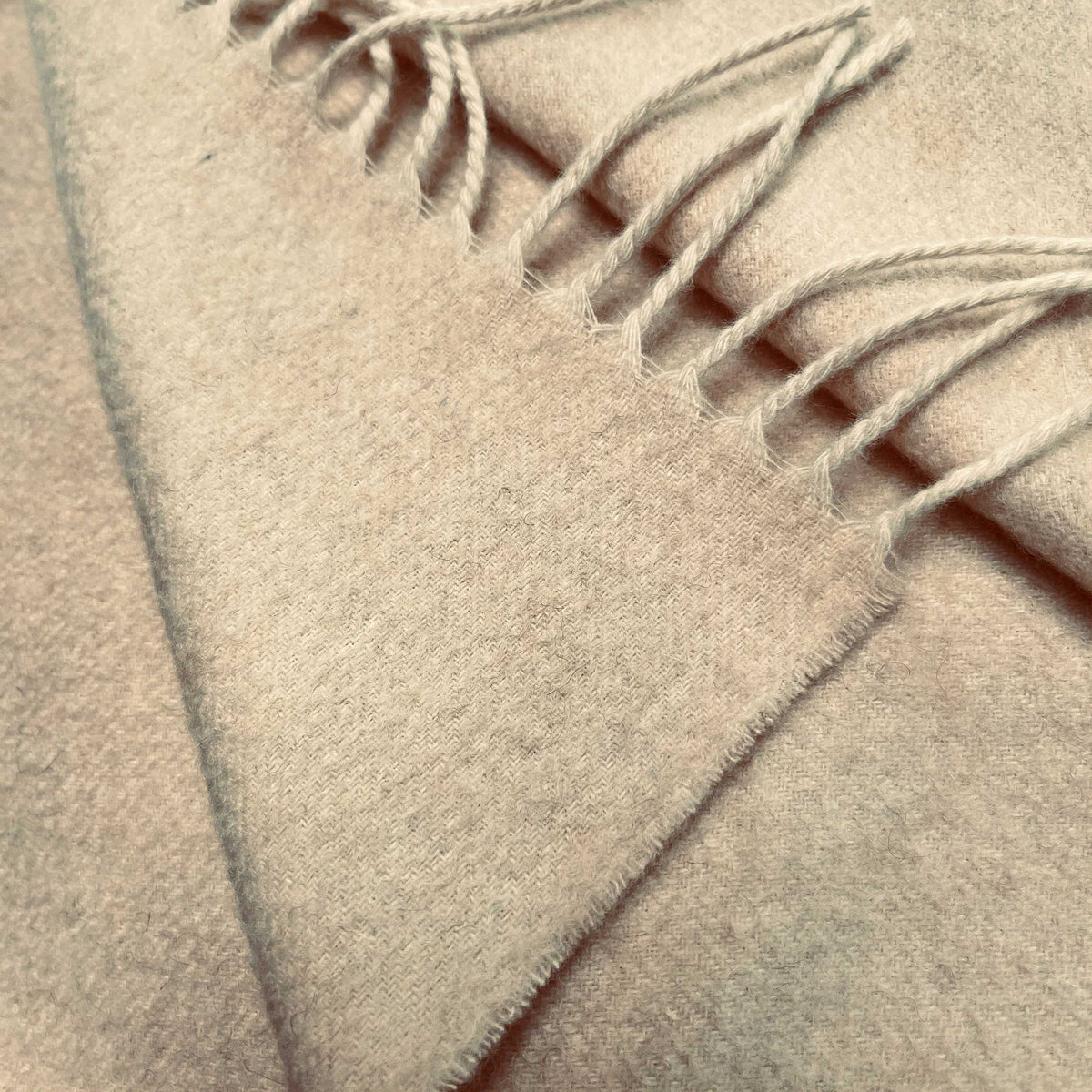 Close up image of the LETTO Coccola 100% cashmere woven throw blanket in beige. data-image-id=