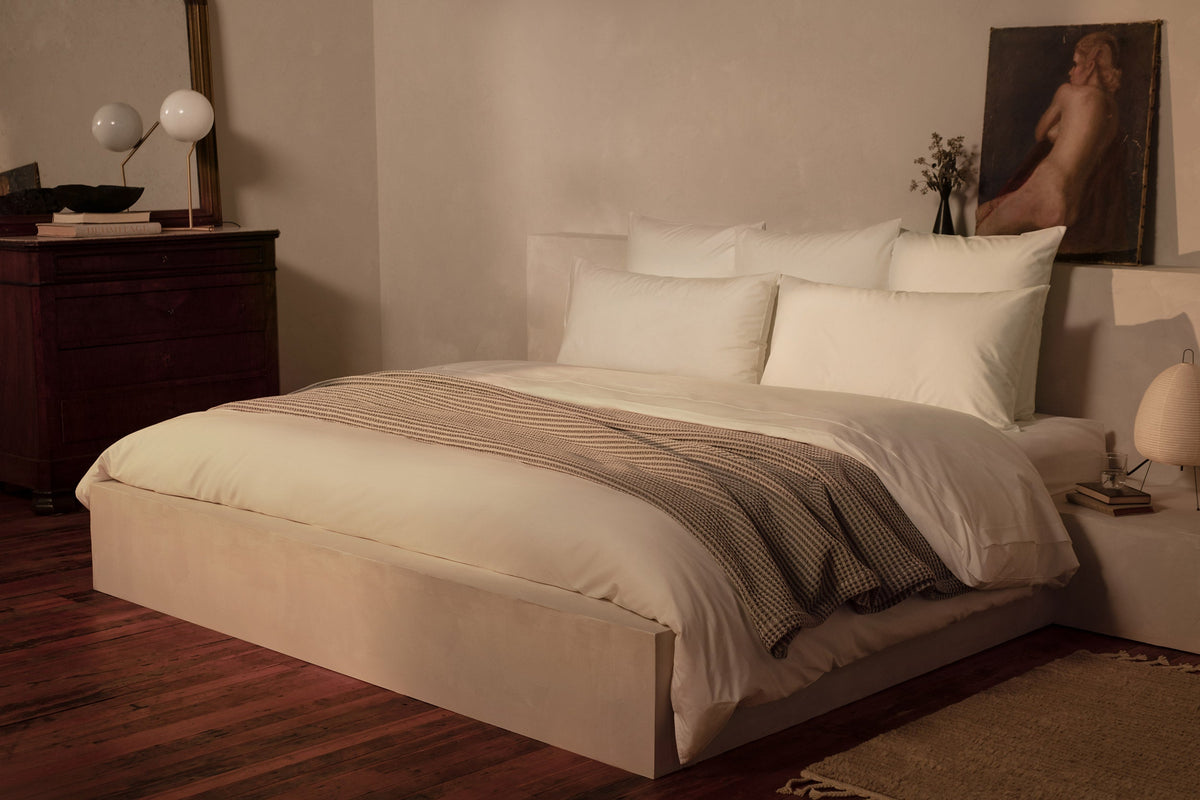 A bedroom with a luxuriously made bed in LETTO Giza Reserve Cotton Percale sheets and duvet cover in color white, with a gray Nido waffleweave cotton blanket. data-image-id=