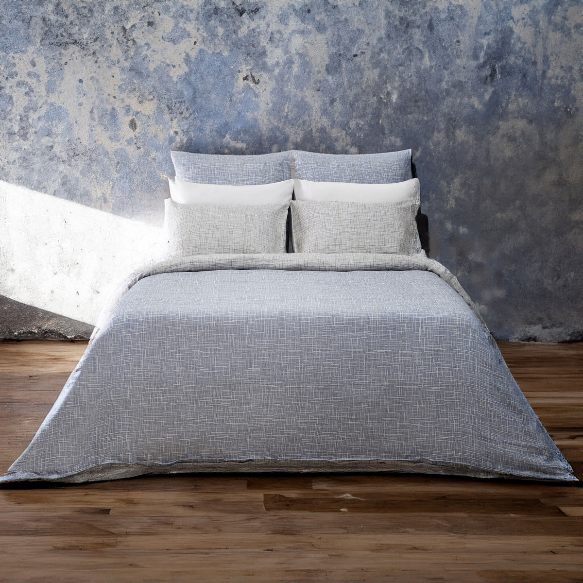 A bed made with the LETTO Mosaico Jacquard Duvet and Sham set in color Denim. data-image-id=