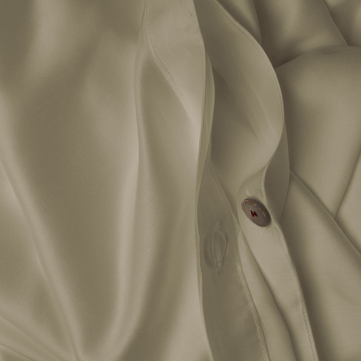 Close up image of the button closure on a LETTO Woodland Silk soft and silky duvet cover in color pistachio. data-image-id=