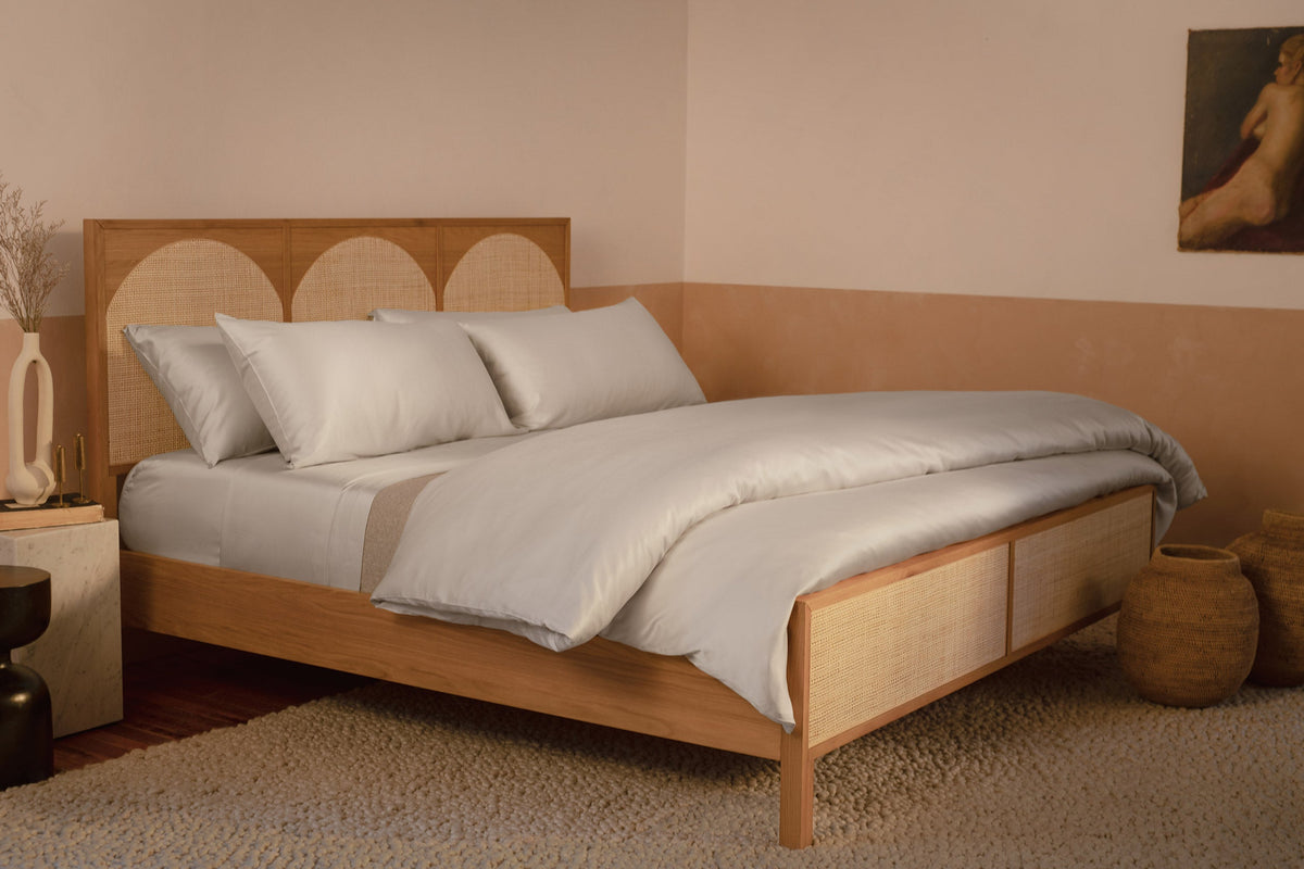 A bedroom with a contemporary wood and rattan bed made with LETTO Woodland Silk beechwood modal sheets and duvet cover in color gray. data-image-id=