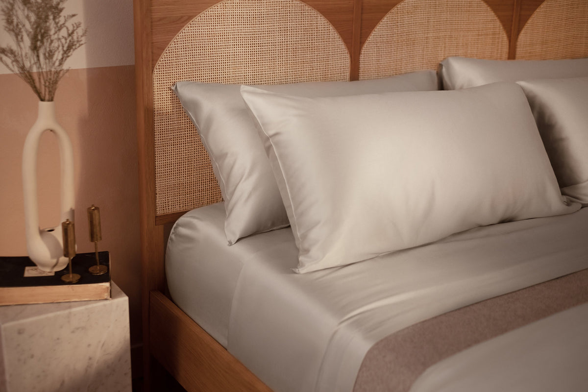 A close up picture of a bed made with LETTO Woodland Silk beechwood modal sheets and pillowcases in color gray. data-image-id=