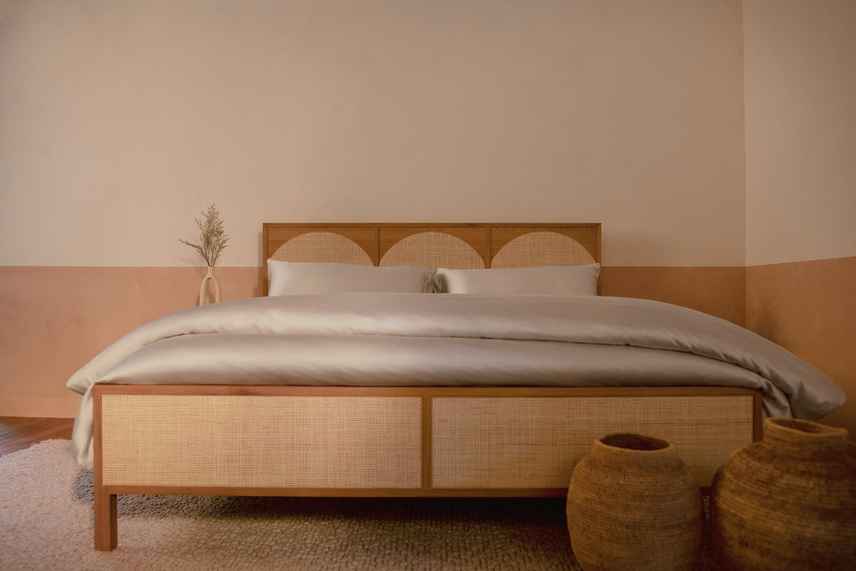 A bedroom with a contemporary wood and rattan bed made with LETTO Woodland Silk beechwood modal sheets and duvet cover in color gray. data-image-id=
