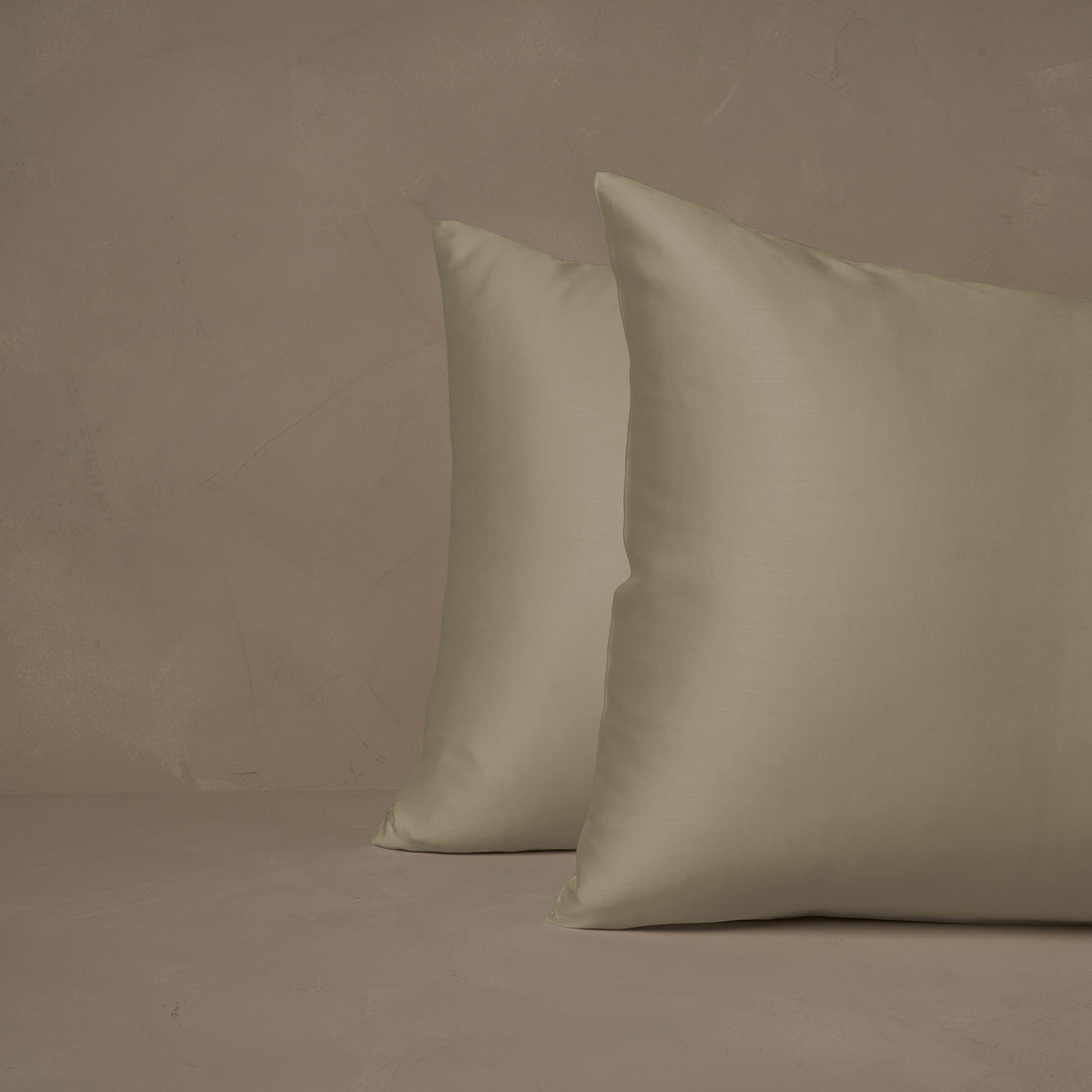 An image of two pillows stacked one in front of the other. The pillow cases are made of LETTO Woodland Silk beechwood modal in color pistacchio. data-image-id=