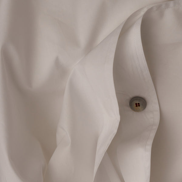 Close up image of the button closure on a LETTO Giza Reserve Cotton Percale crisp and cool duvet cover in color white.