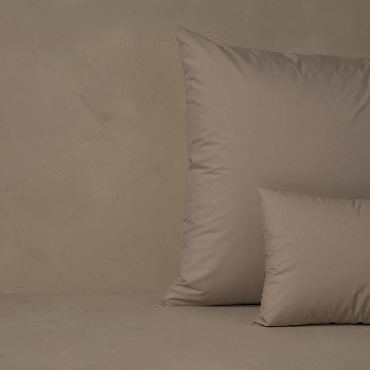 An image of a small boudoir or travel size pillow stacked in front of a large euro size pillow. The pillow cases are made of LETTO's crisp and cool Classic Cotton Percale in color gray. data-image-id=
