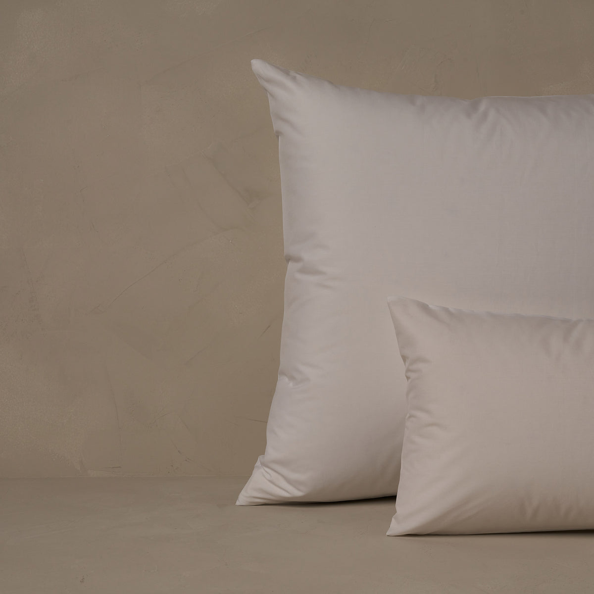 An image of a small boudoir or travel size pillow stacked in front of a large euro size pillow. The pillow cases are made of LETTO's crisp and cool Classic Cotton Percale in color white. data-image-id=