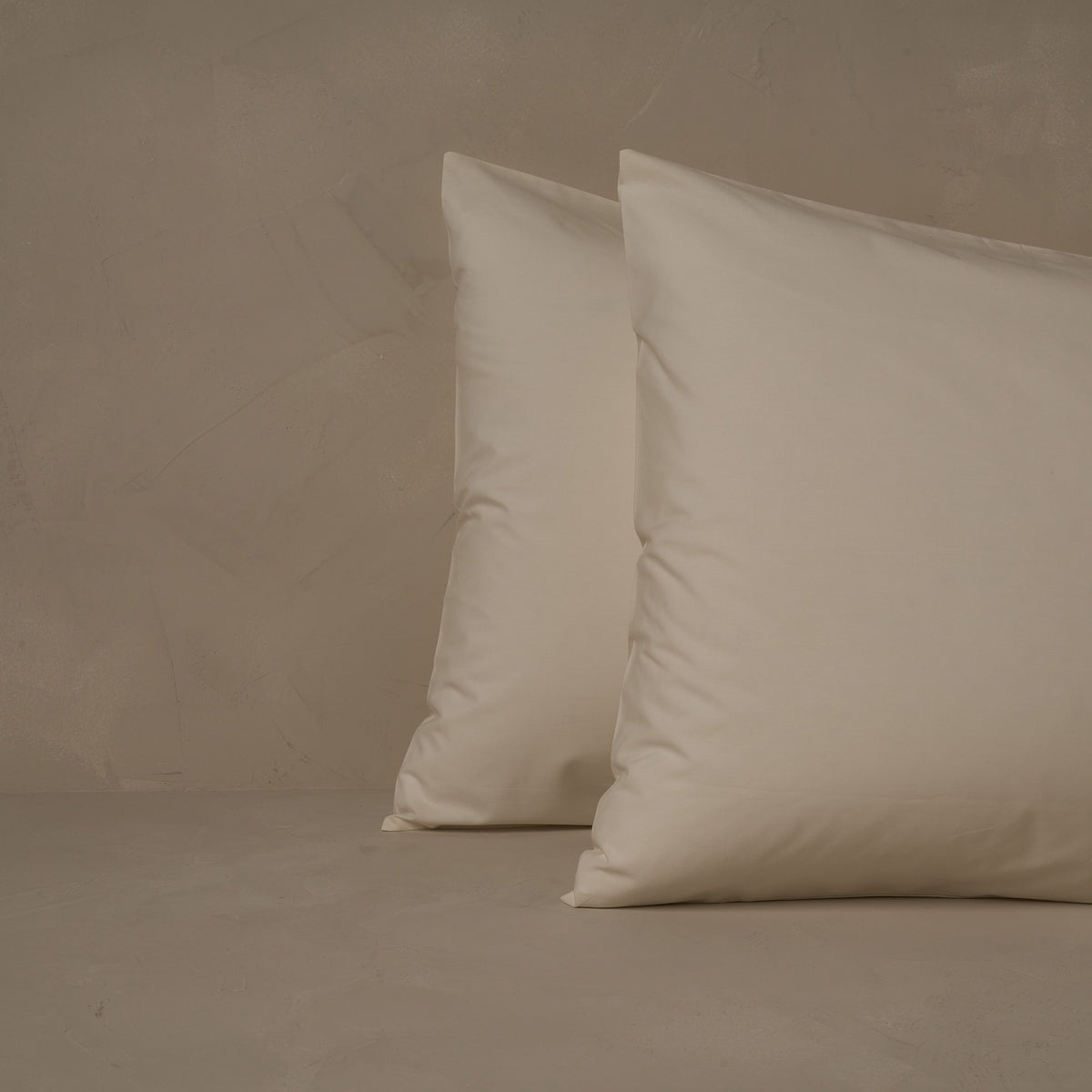 An image of two pillows stacked one in front of the other. The pillow cases are made of LETTO's cool and crisp Classic Cotton Percale in color ivory. data-image-id=