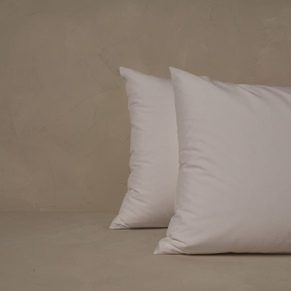 An image of two pillows stacked one in front of the other. The pillow cases are made of LETTO's cool and crisp Classic Cotton Percale in color white.