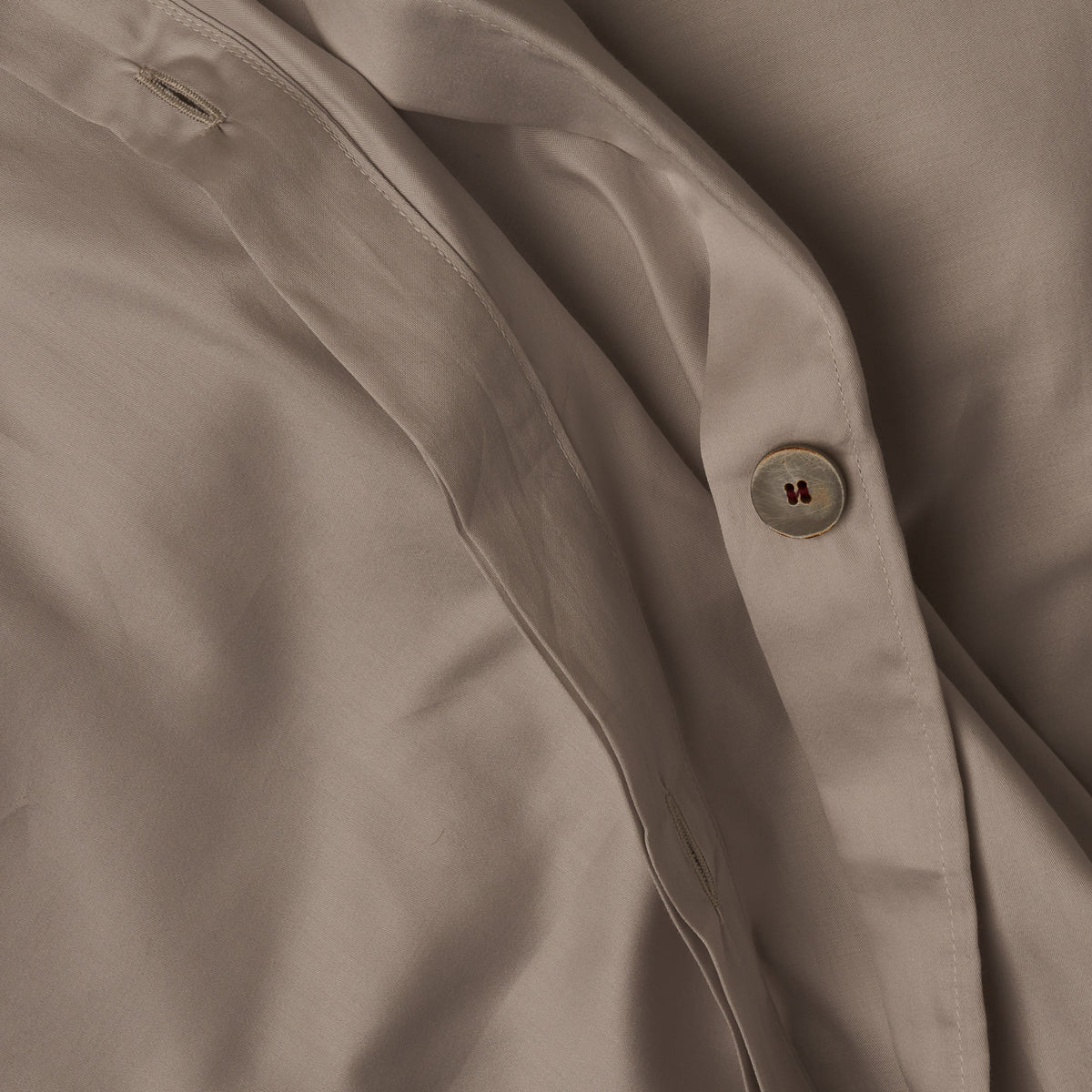 Close up image of the button closure on a LETTO Classic Cotton Sateen duvet cover in color gray. data-image-id=