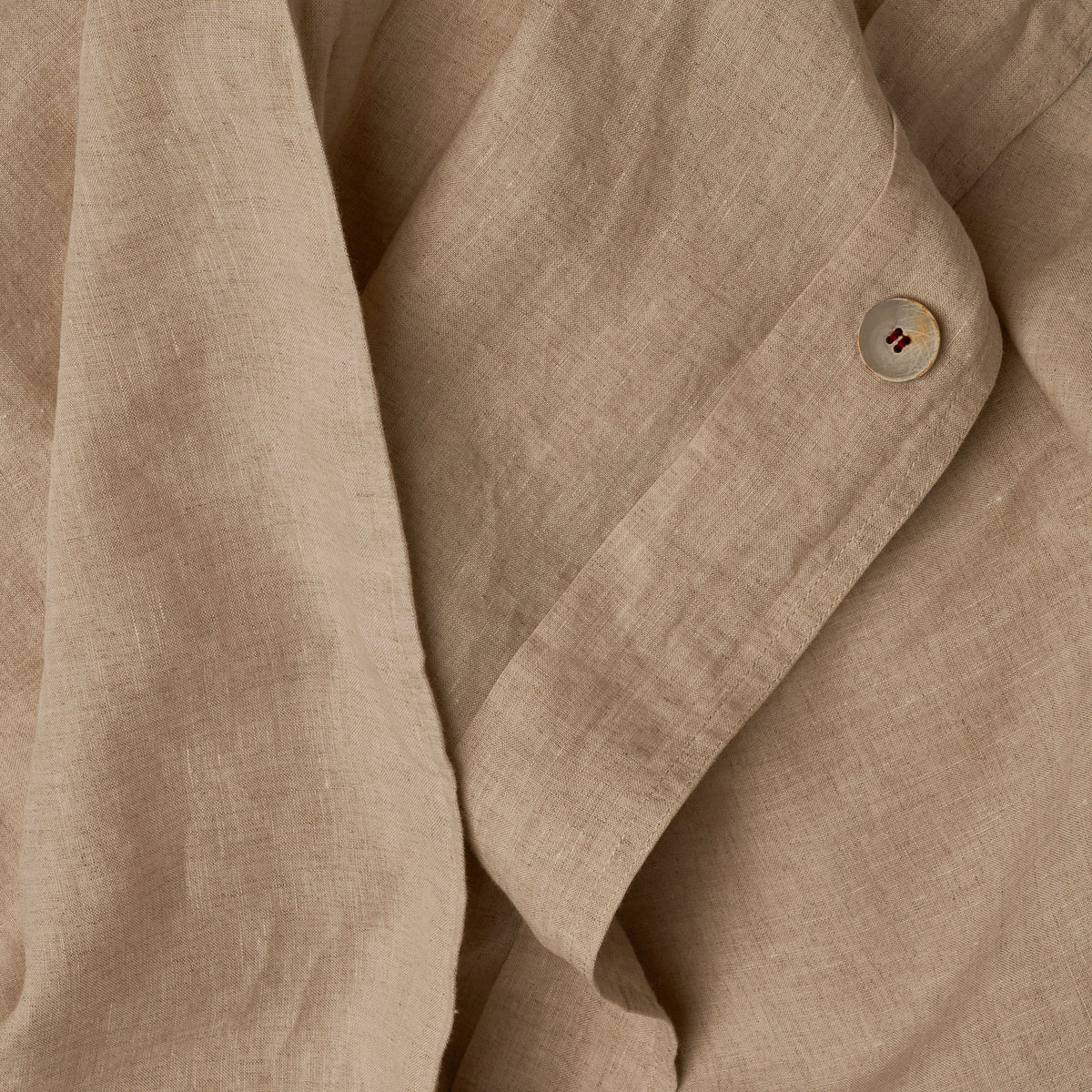 Close up image of the button closure on a LETTO Classic Linen crisp and breathable duvet cover in color natural. data-image-id=