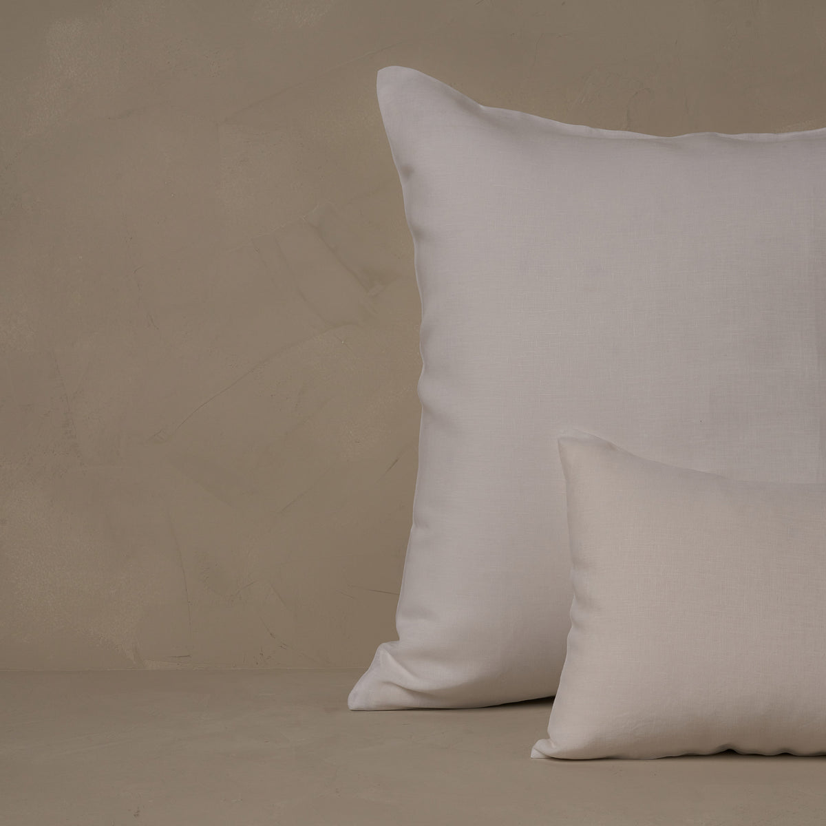 An image of a small boudoir or travel size pillow stacked in front of a large euro size pillow. The pillow cases are made in Italy of breathable and relaxed 100% linen, LETTO Lino Primo in color white. data-image-id=