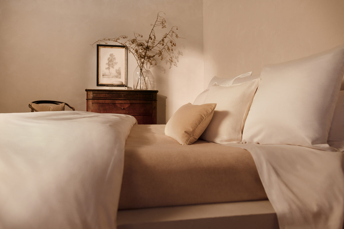 Image of a bed with the LETTO 100% cashmere Monte Bianco blanket in cream. data-image-id=