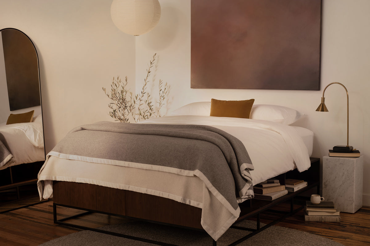 Image of a bed draped with the LETTO 100% cashmere Monte Bianco blanket in gray. data-image-id=