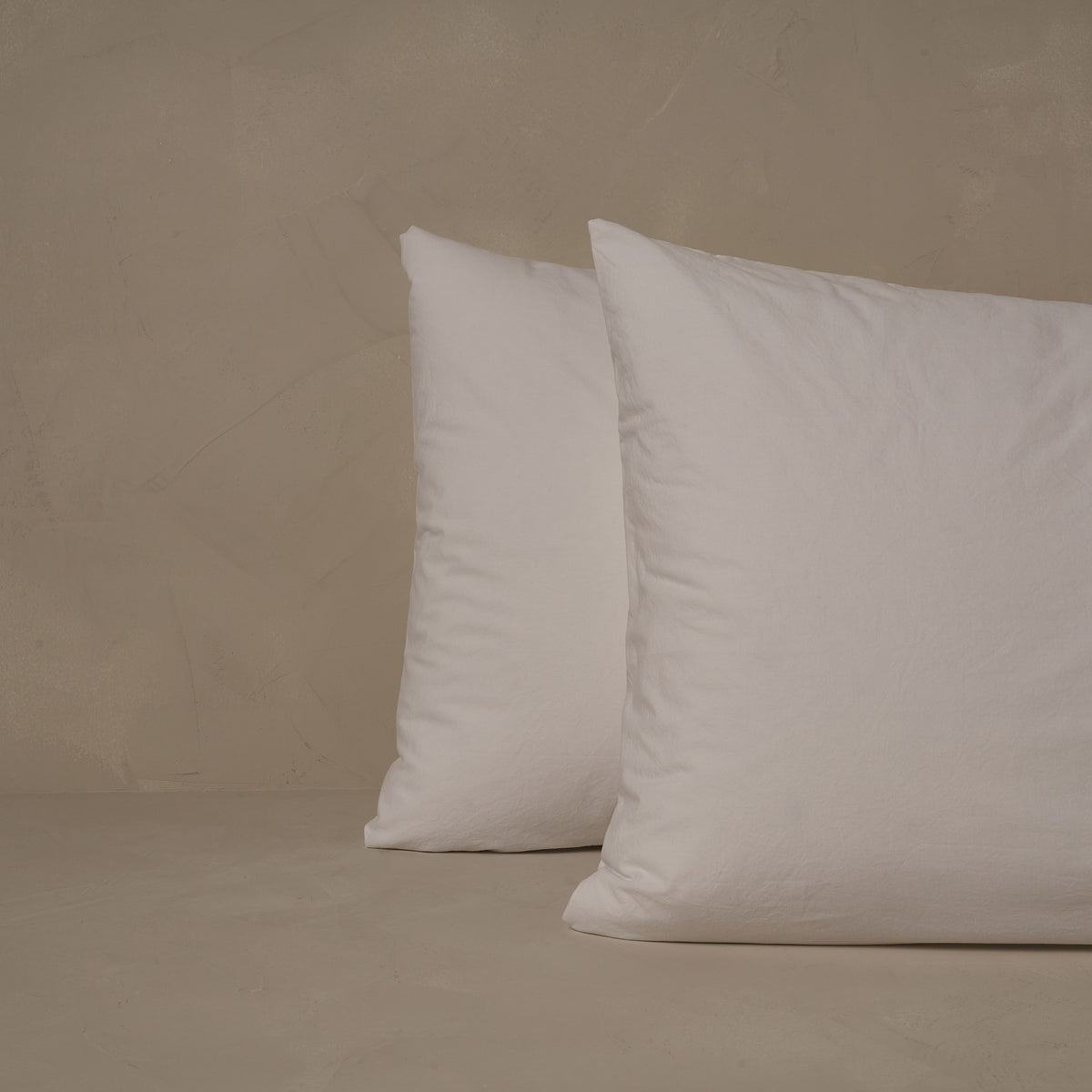 An image of two pillows stacked one in front of the other. The pillow cases are made of LETTO 100% Organic Cotton Percale in color white. data-image-id=