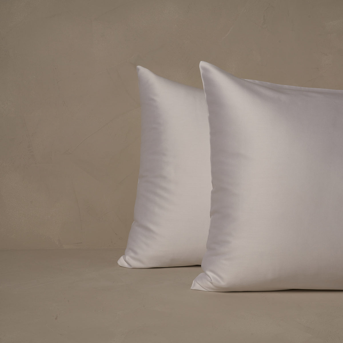 An image of two pillows stacked one in front of the other. The pillow cases are made of LETTO Sea Island Cotton Sateen in color white. data-image-id=