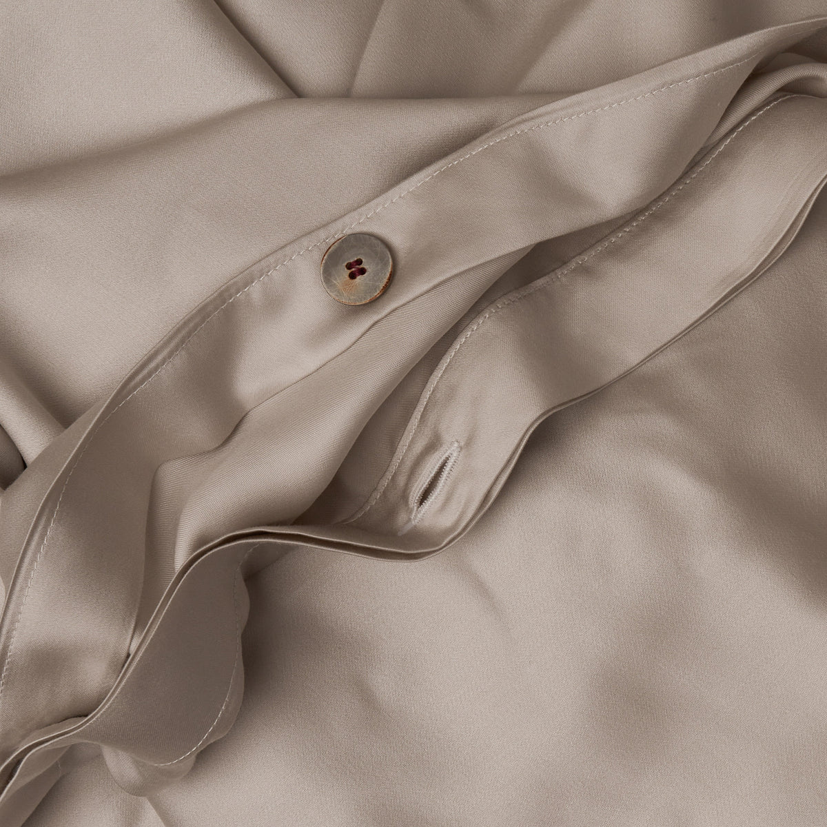 Close up image of the button closure on a LETTO Woodland Silk soft and silky duvet cover in color gray. data-image-id=