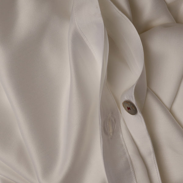 Close up image of the button closure on a LETTO Woodland Silk soft and silky duvet cover in color white.