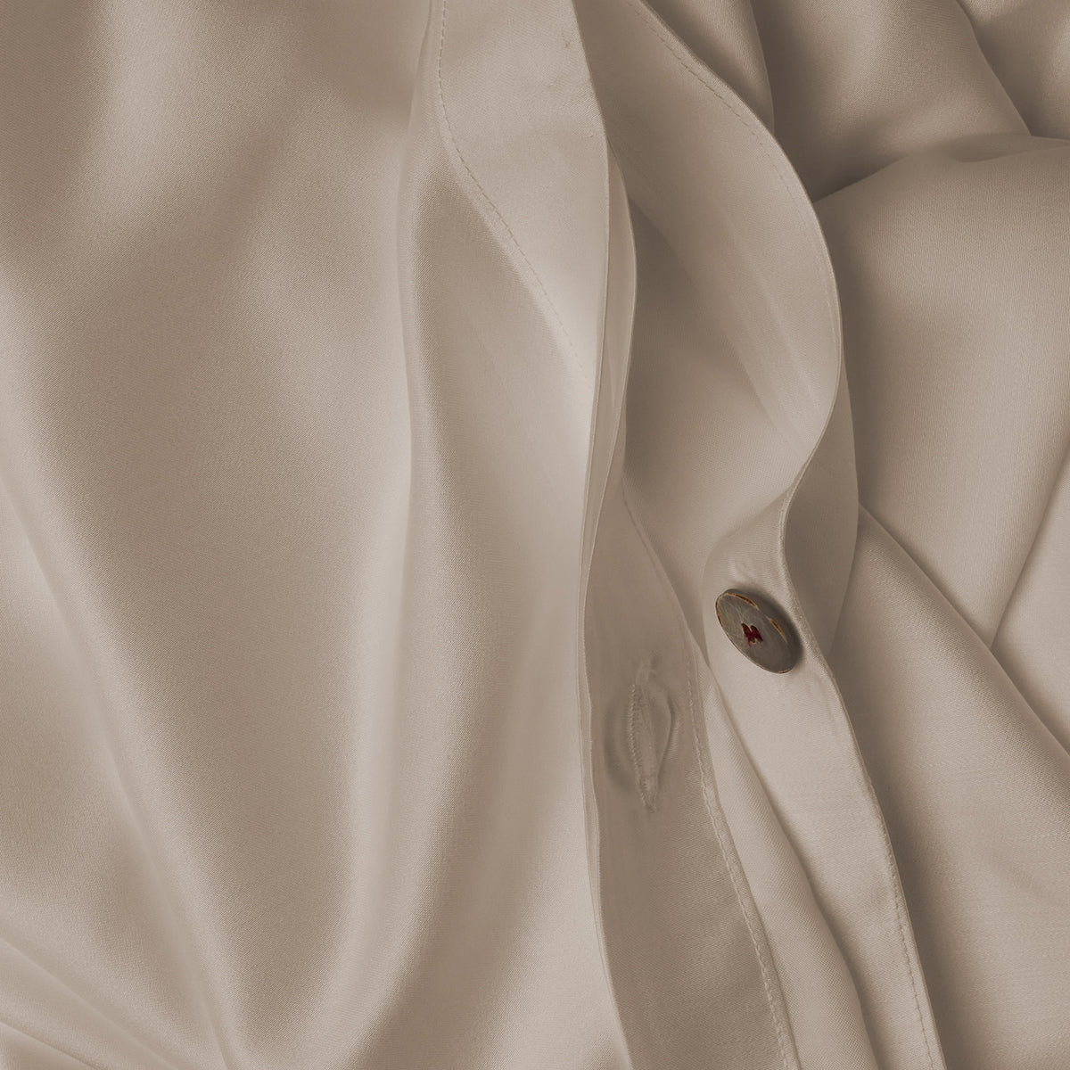 Close up image of the button closure on a LETTO Woodland Silk soft and silky duvet cover in color ivory. data-image-id=