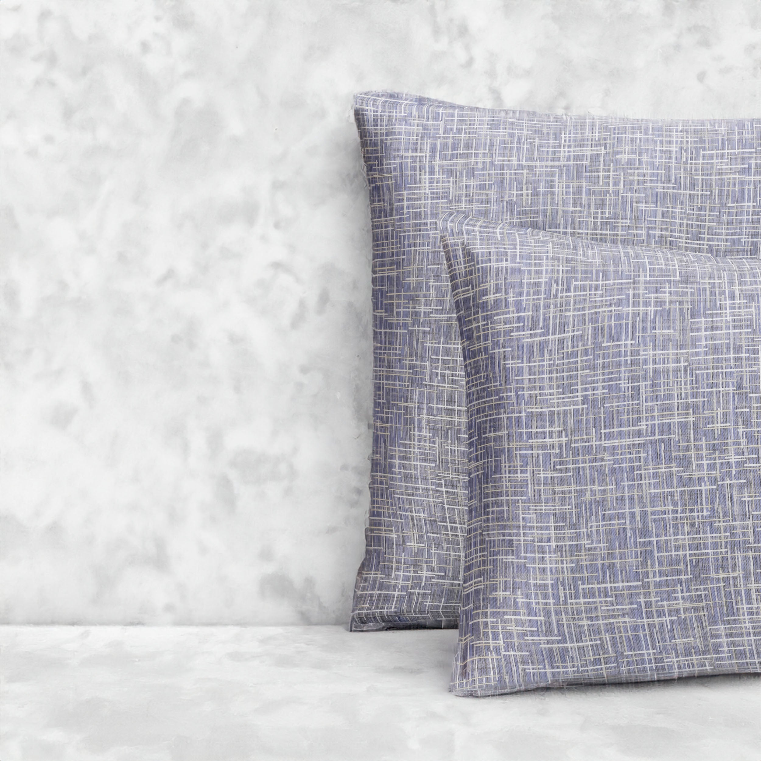 An image of two pillows stacked one in front of the other. The pillow cases are made of LETTO Mosaico Jacquard fabric in color Denim.