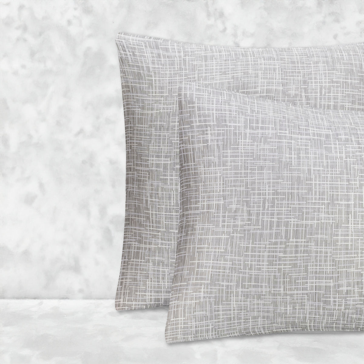 An image of two pillows stacked one in front of the other. The pillow cases are made of LETTO Mosaico Jacquard fabric in color Heather. data-image-id=