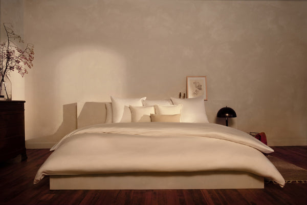 A bedroom with a luxuriously made bed in LETTO Sea Island Cotton Sateen sheets and duvet cover in color white.
