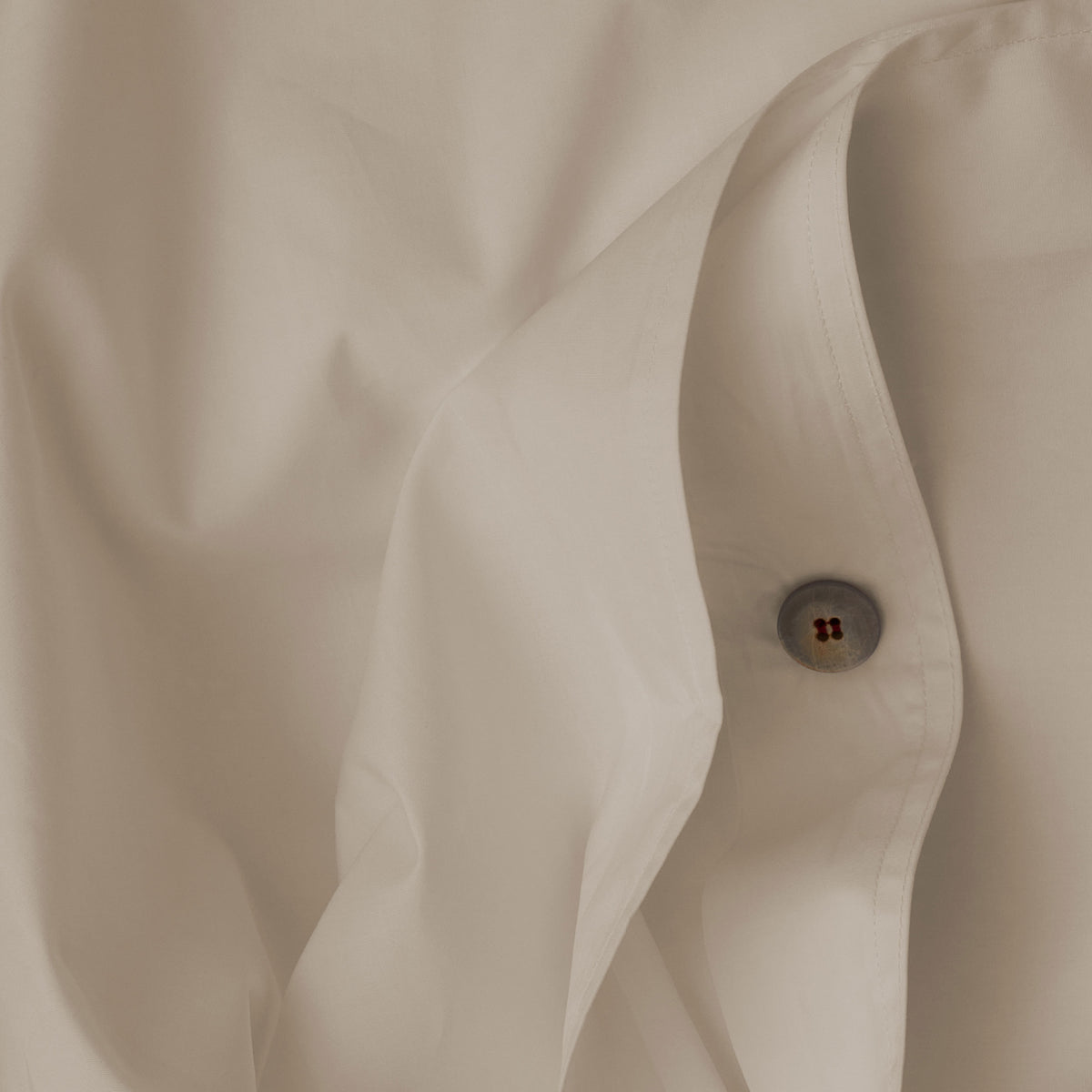Close up image of the button closure on a LETTO Americano Cotton Percale cool and crisp duvet cover in color ivory. data-image-id=
