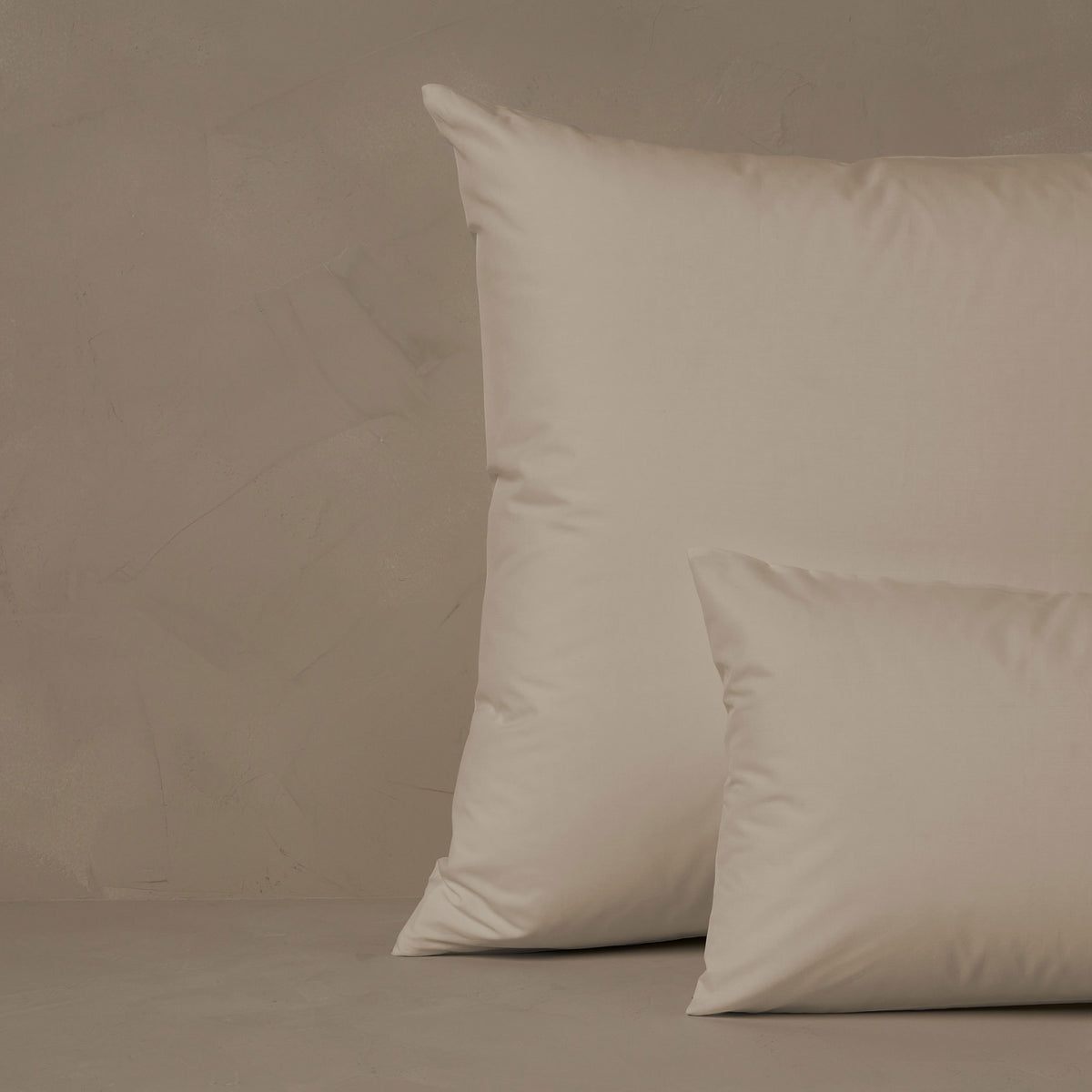 An image of a small boudoir or travel size pillow stacked in front of a large euro size pillow. The pillow cases are made in Italy of LETTO Americano Cotton Percale in color ivory, a crisp and cool American grown Supima cotton. data-image-id=
