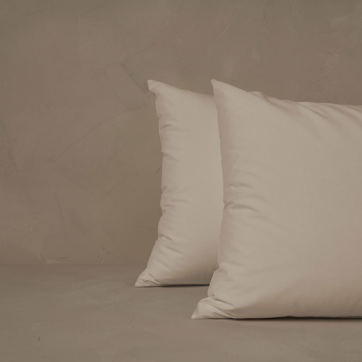 An image of two pillows stacked one in front of the other. The pillow cases are made of LETTO Americano Cotton Percale in color ivory. data-image-id=