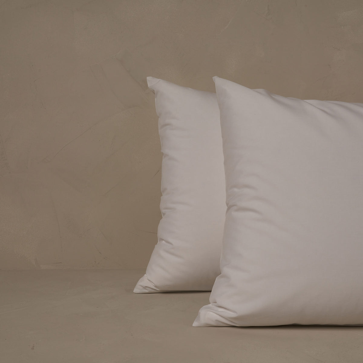 An image of two pillows stacked one in front of the other. The pillow cases are made of LETTO Americano Cotton Percale in color white. data-image-id=