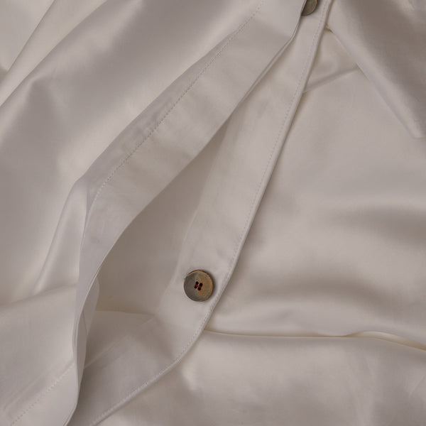 Close up image of the button closure on a LETTO Americano Cotton Sateen warm and buttery duvet cover in color white.