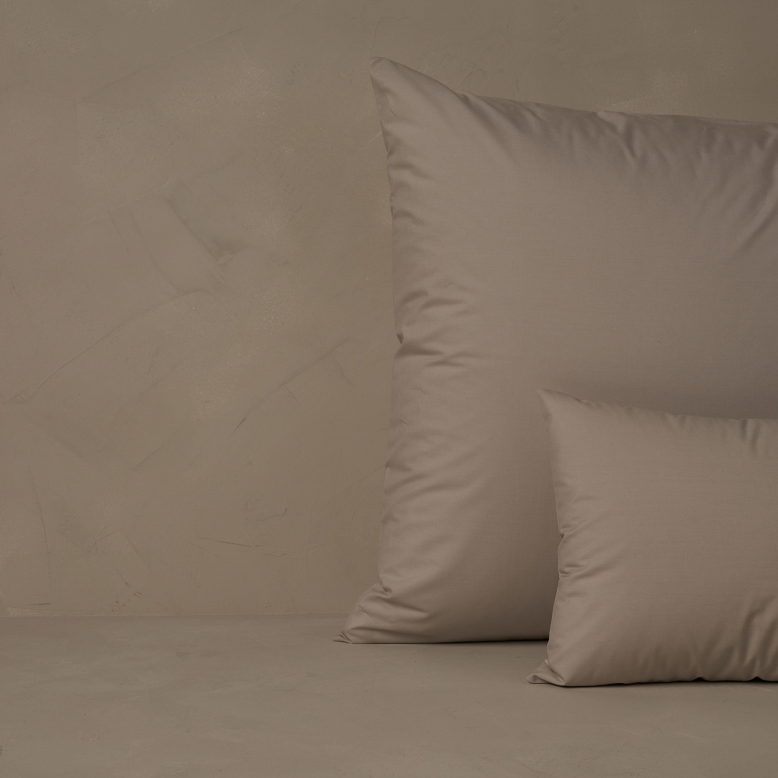 An image of a small boudoir or travel size pillow stacked in front of a large euro size pillow. The pillow cases are made of LETTO's crisp and cool Classic Cotton Percale in color gray.