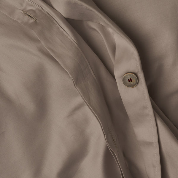 Close up image of the button closure on a LETTO Classic Cotton Sateen duvet cover in color gray.
