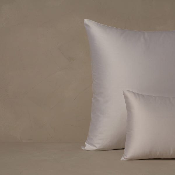 An image of a small boudoir or travel size pillow stacked in front of a large euro size pillow. The pillow cases are made of LETTO's warm and buttery Classic Cotton Sateen in color white.