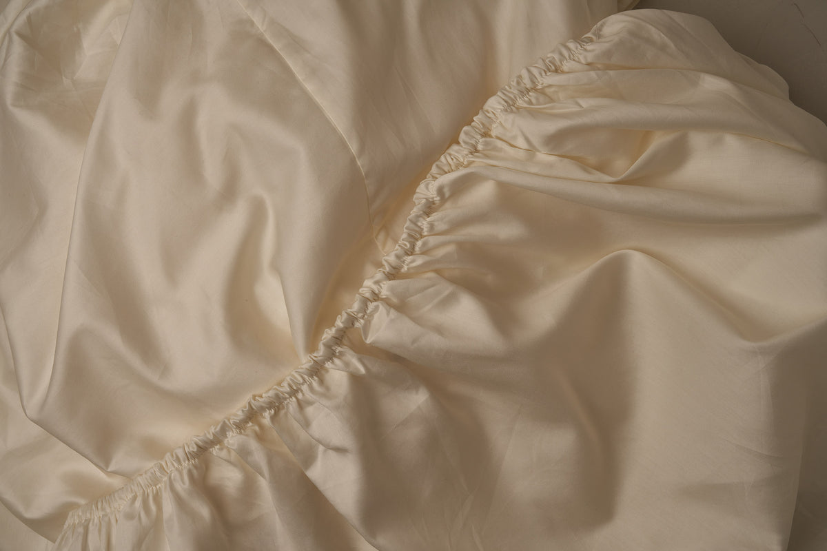 Warm and buttery Classic Cotton Sateen fitted sheet in color ivory, made in Italy. data-image-id=