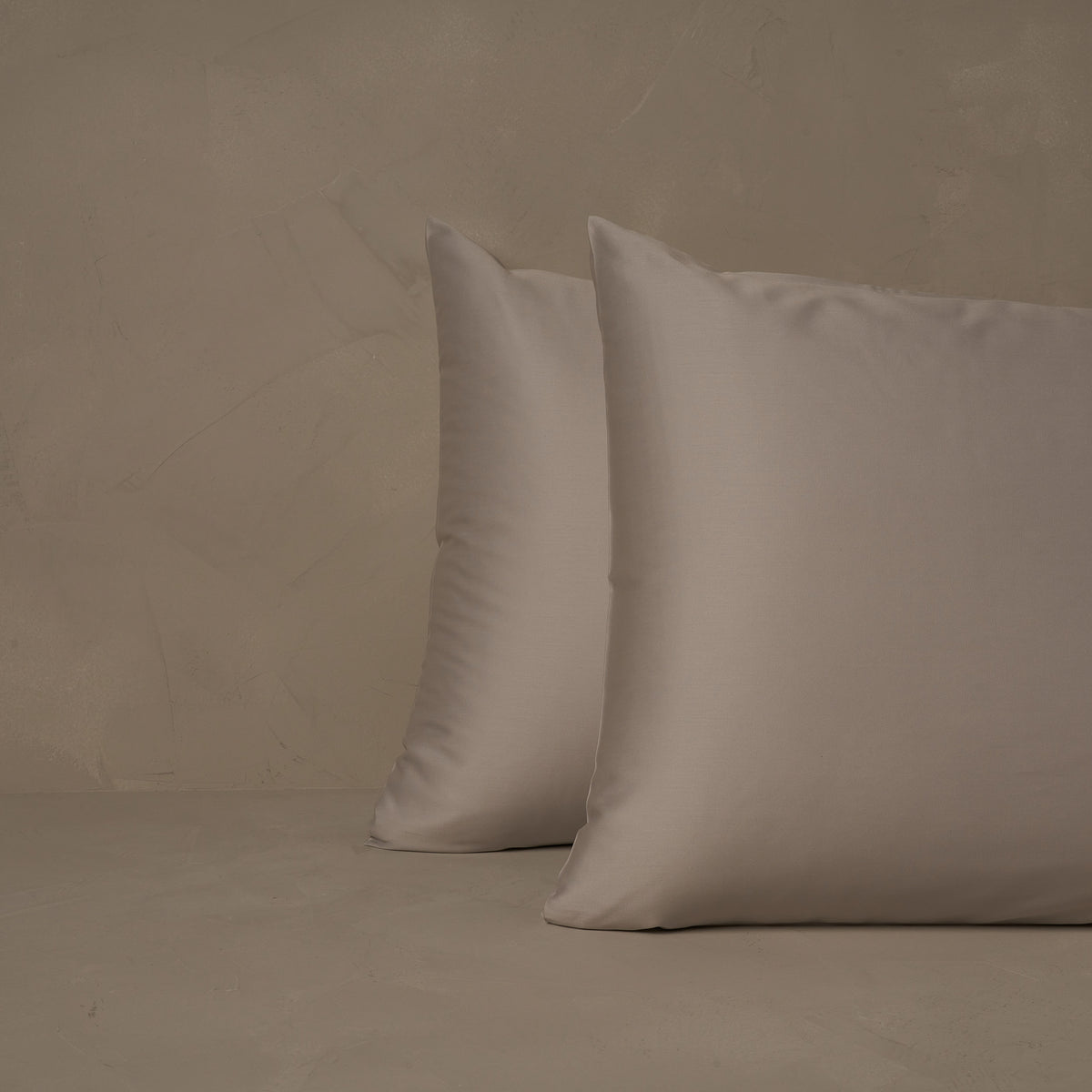An image of two pillows stacked one in front of the other. The pillow cases are made of LETTO's warm and buttery Classic Cotton Sateen in color gray. data-image-id=