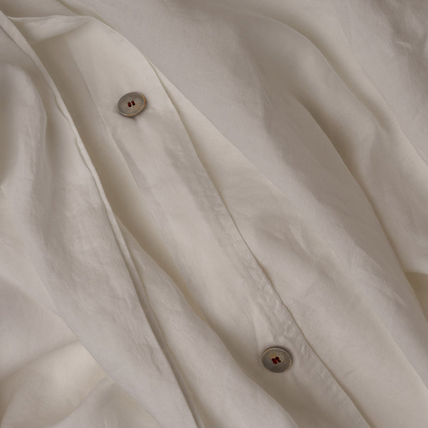 Close up image of the button closure on a LETTO Classic Linen crisp and breathable duvet cover in color white.