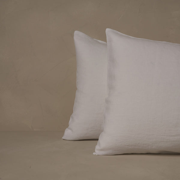 An image of two pillows stacked one in front of the other. The pillow cases are made of LETTO Classic Linen in color white.