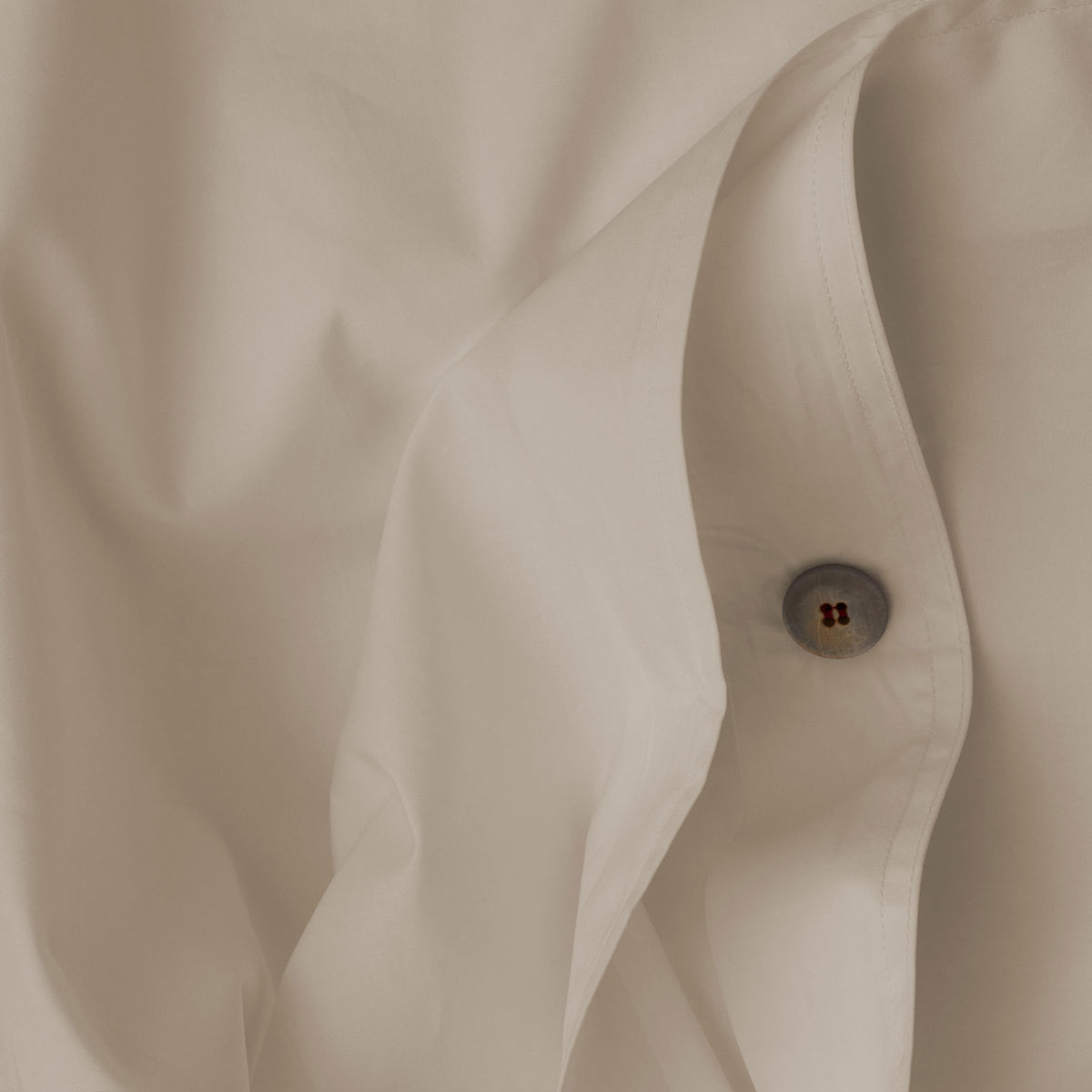 Close up image of the button closure on a LETTO Giza Reserve Cotton Percale crisp and cool duvet cover in color ivory. data-image-id=