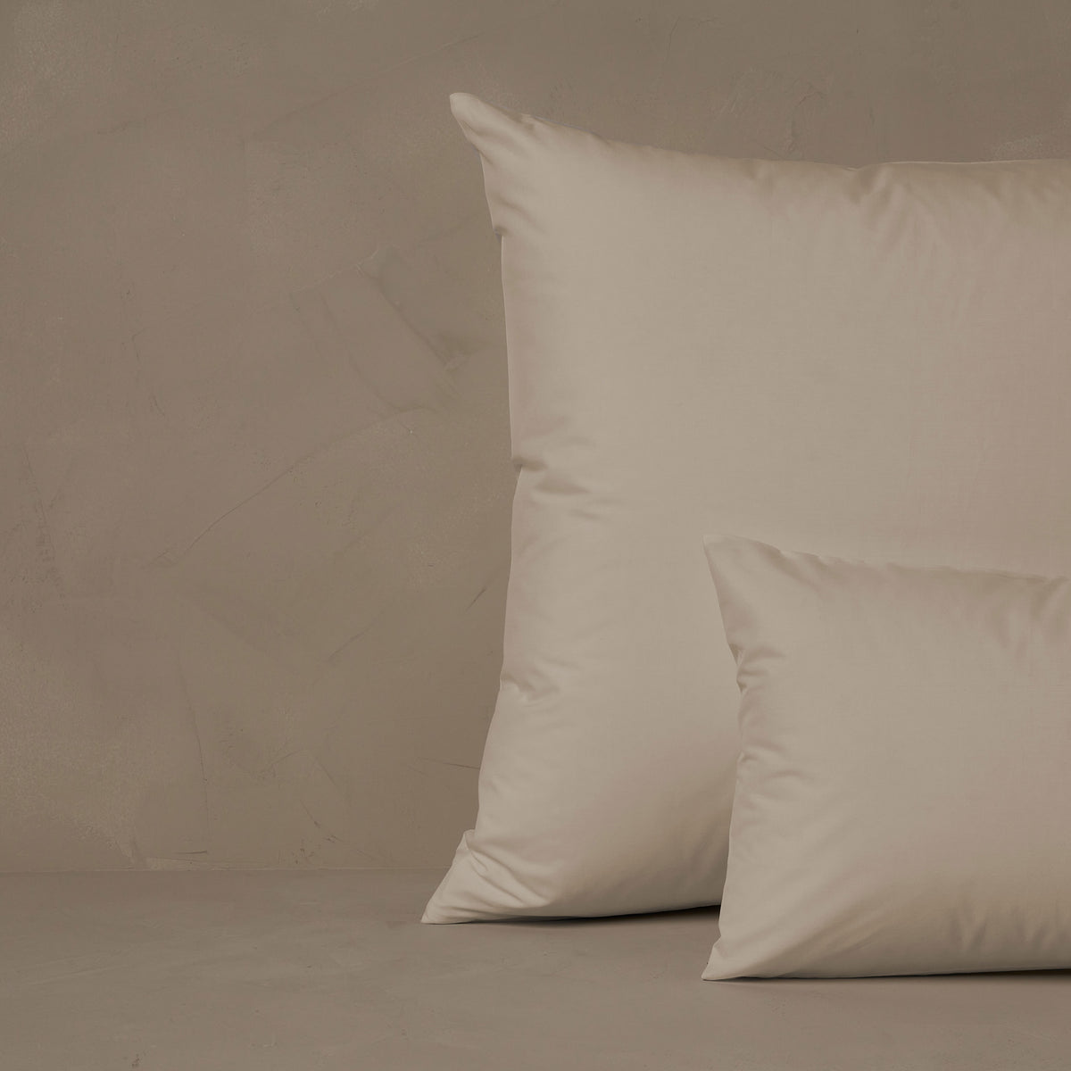 An image of a small boudoir or travel size pillow stacked in front of a large euro size pillow. The pillow cases are made in Italy of crisp and cool LETTO Giza Reserve Cotton Percale in color ivory. data-image-id=