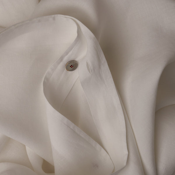 Close up image of the button closure on a LETTO Lino Primo crisp and breathable duvet cover in color white.