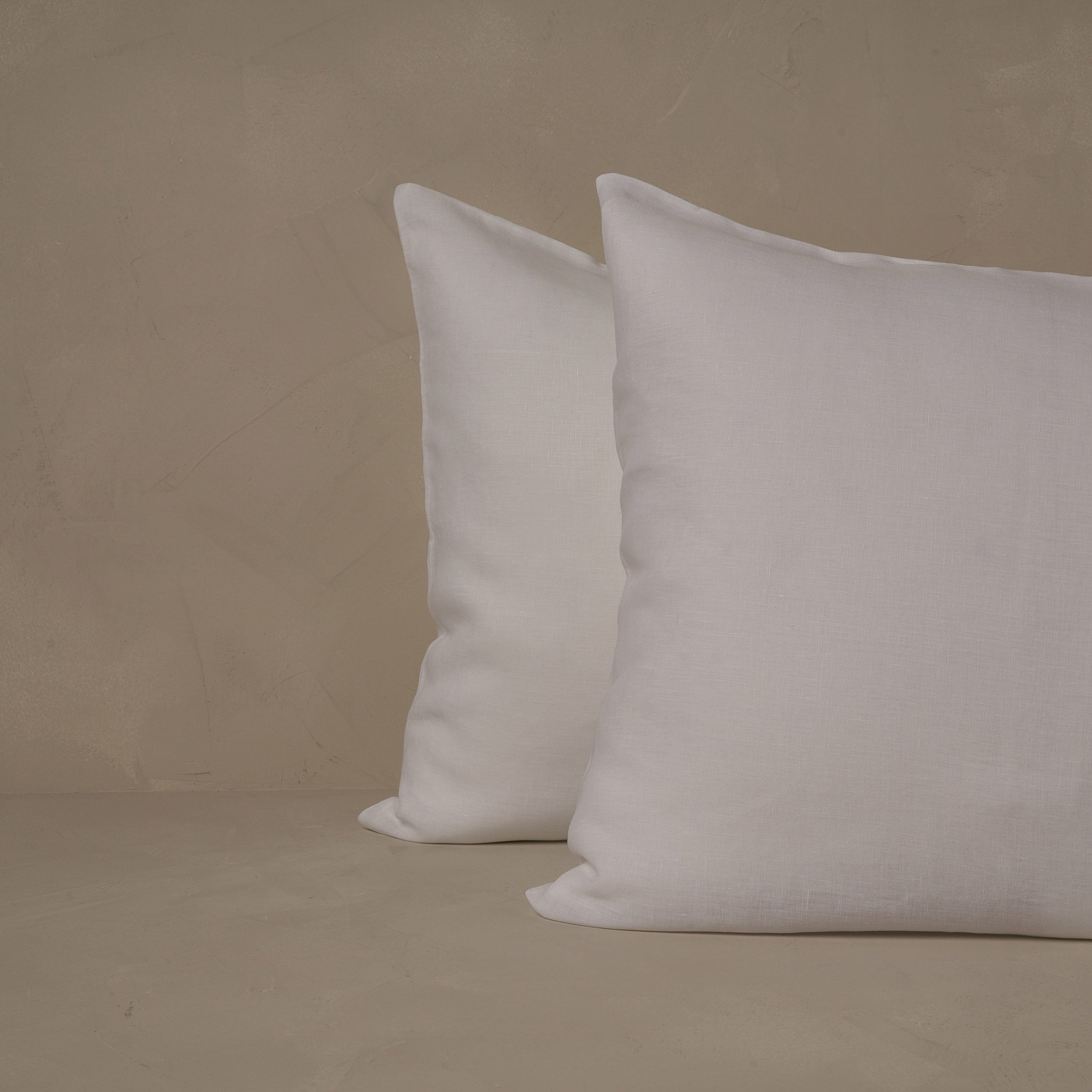 An image of two pillows stacked one in front of the other. The pillow cases are made of LETTO 100% linen Lino Primo in color white.