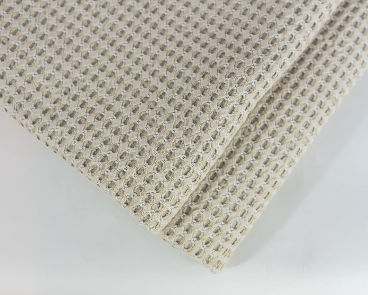 Close up image of the LETTO Nido 100% cotton textured waffleweave blanket in color beige, made in Italy data-image-id=