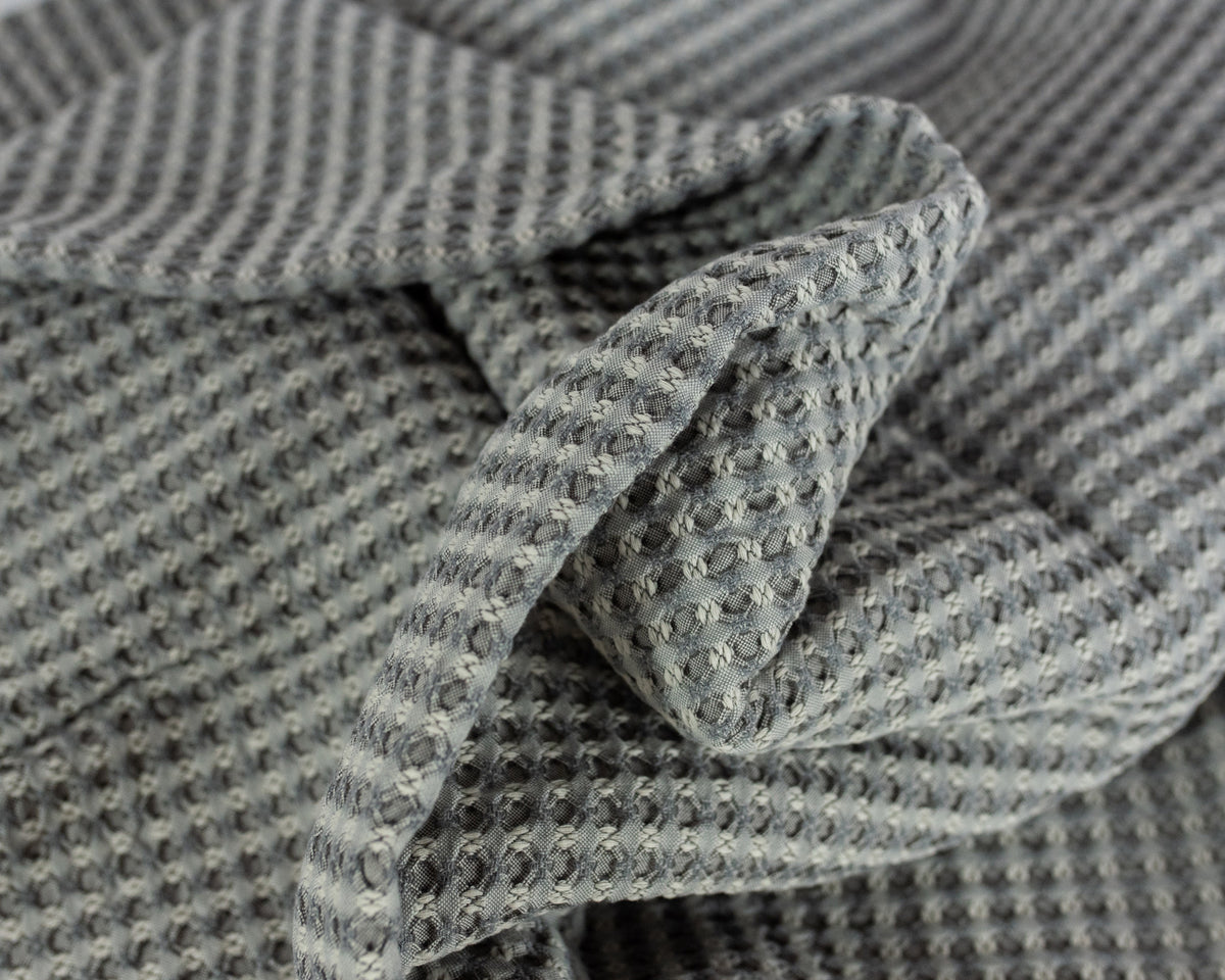 Close up image of the LETTO Nido 100% cotton textured waffleweave blanket in color gray, made in Italy data-image-id=