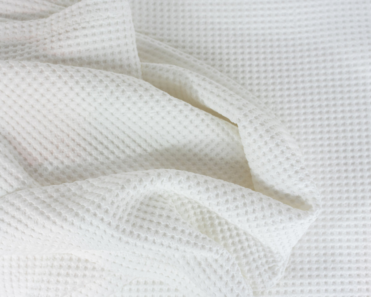 Close up image of the LETTO Nido 100% cotton textured waffleweave blanket in color white, made in Italy data-image-id=