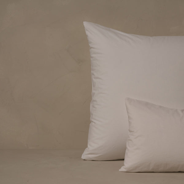 An image of a small boudoir or travel size pillow stacked in front of a large euro size pillow. The pillow cases are made in Italy of crisp and cool LETTO 100% Organico Cotton Percale in color white.