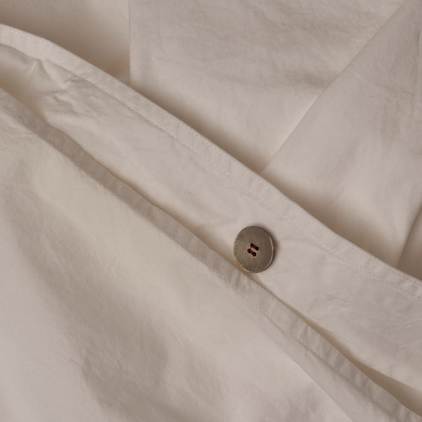 Close up image of the button closure on a LETTO 100% Organico Cotton Percale crisp and cool duvet cover in color white.
