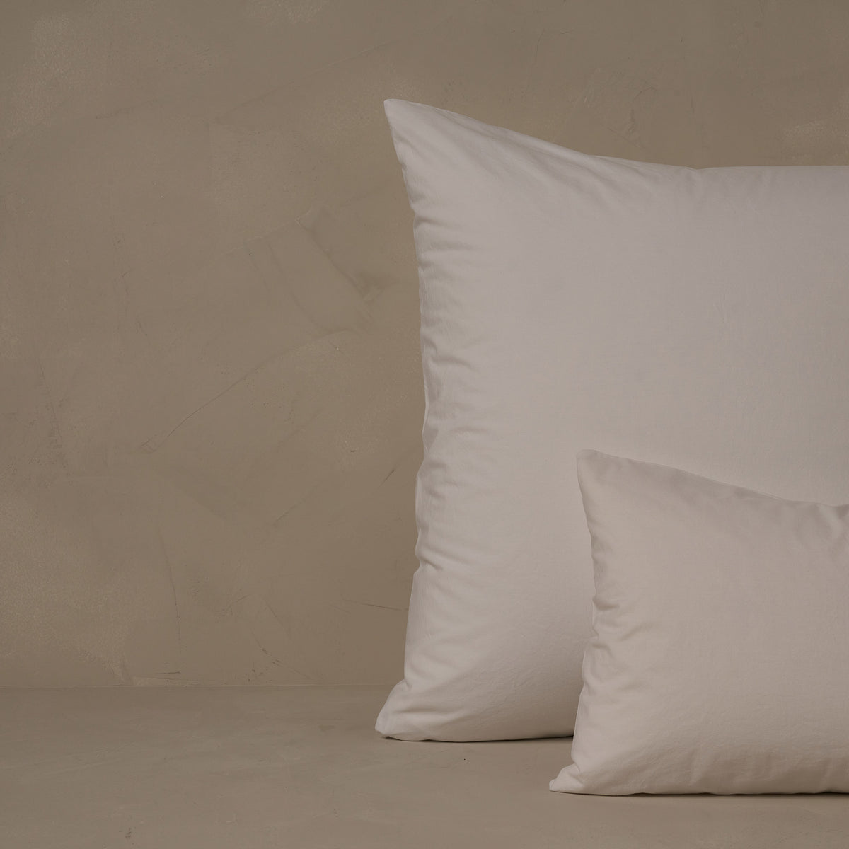 An image of a small boudoir or travel size pillow stacked in front of a large euro size pillow. The pillow cases are made in Italy of crisp and cool LETTO 100% Organico Cotton Percale in color white. data-image-id=
