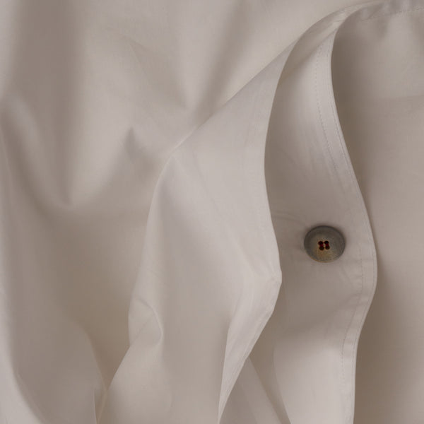 Close up image of the button closure on a LETTO Sea Island Cotton Percale ultra soft and cool duvet cover in color white.
