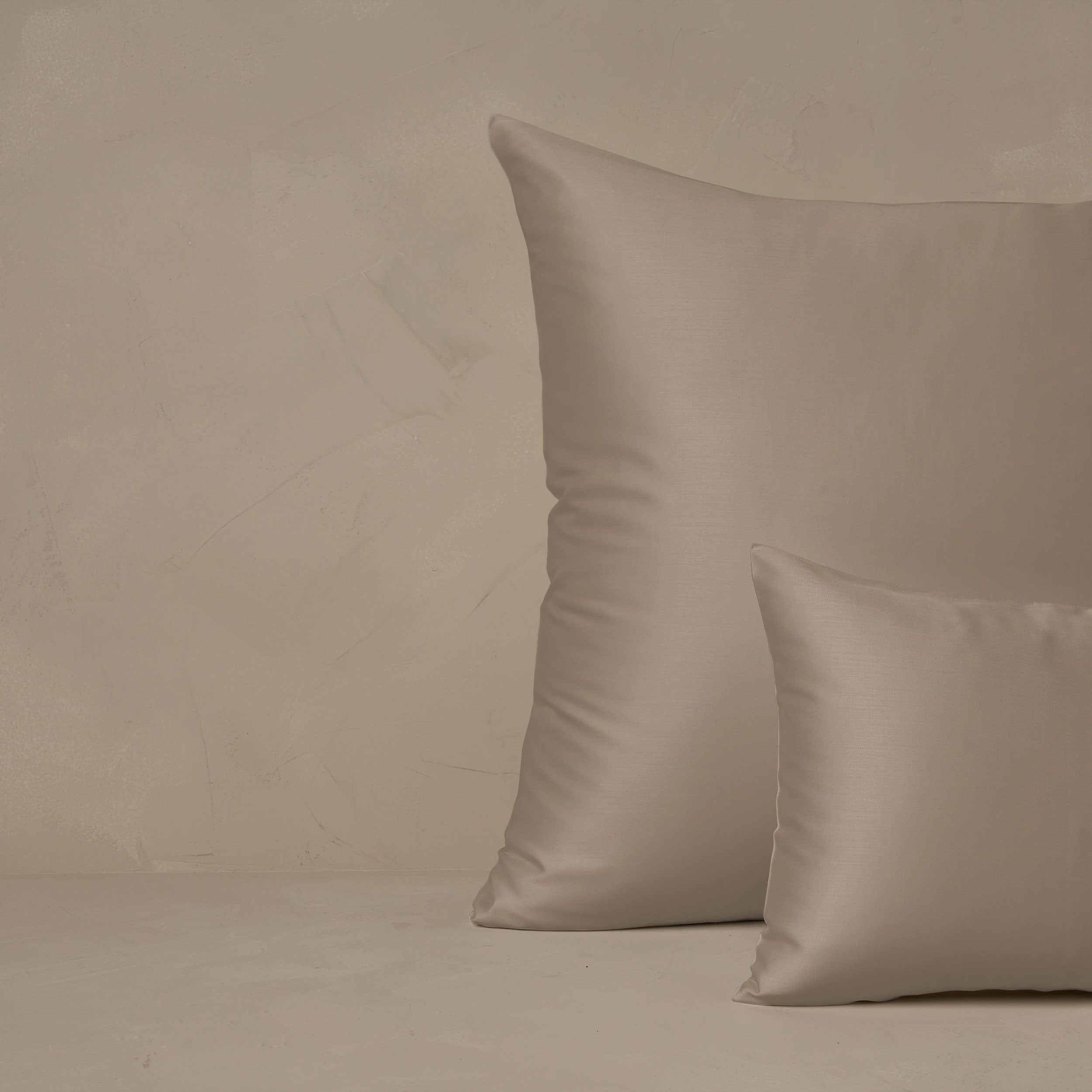 An image of a small boudoir or travel size pillow stacked in front of a large euro size pillow. The pillow cases are made in Italy of LETTO Woodland Silk fabric in color Candlelight, a smooth and silky beechwood modal.